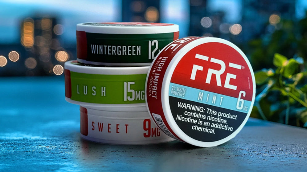 FRE nicotine pouches in Mint, Lush, Sweet and Wintergreen stacked on a table with a cityscape background