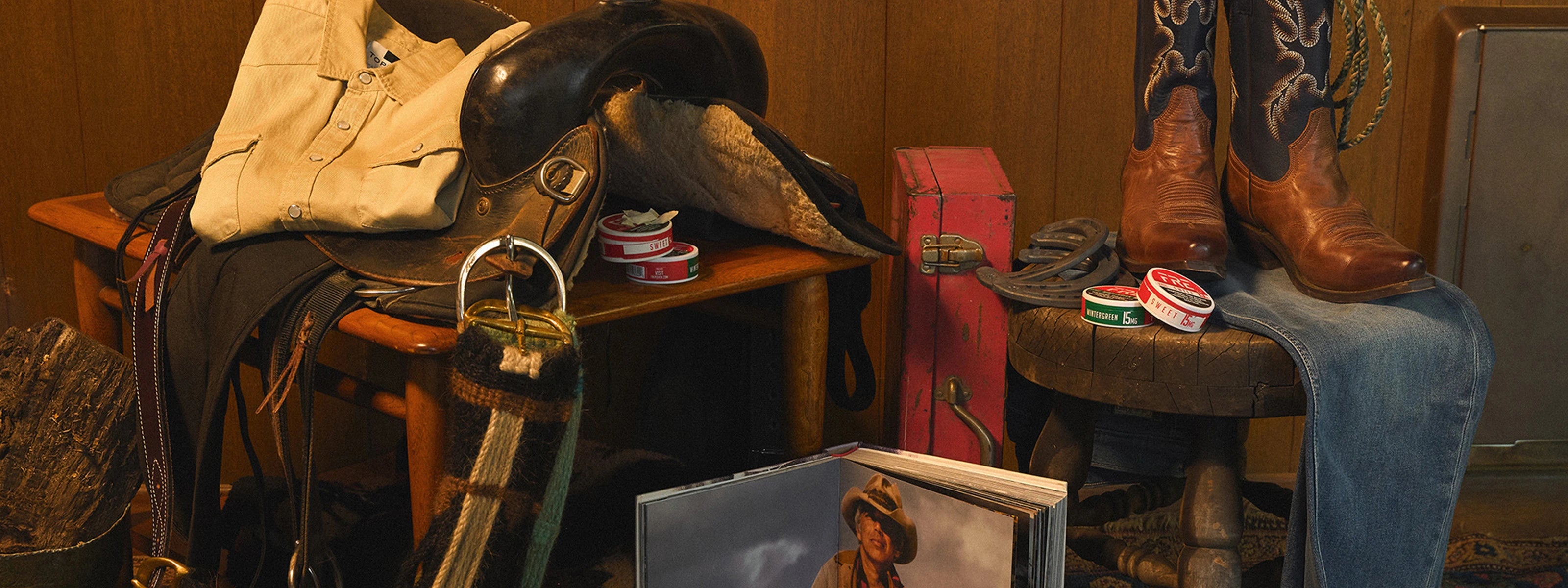 Rustic Western display featuring saddle, boots, and FRE nicotine pouch tins in Mint and Wintergreen varieties