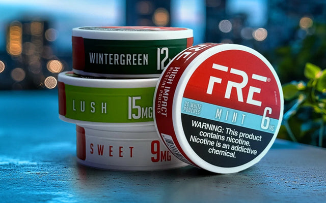 FRE nicotine pouches in Mint, Lush, Sweet and Wintergreen stacked on a table with a cityscape background